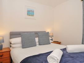 A bedroom with a bed and bedside tables at Norvys in Bossiney