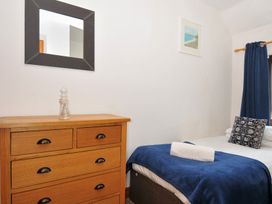 A bedroom with a chest of drawers and a bed at Norvys in Bossiney