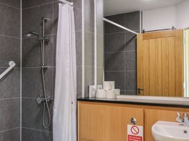 A bathroom with shower, sink, and toilet paper at Bedroom 36 in Penrith