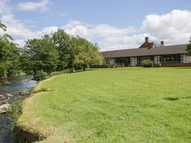 An outdoor area with grass, river, and a building at Bedroom 21 in Penrith