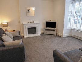 A living room with a sofa, lamp, fireplace and television at Bungalow 19 Eamont Park Penrith