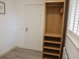 A bedroom with a wardrobe and wood flooring at Bungalow 19 Eamont Park in Penrith