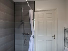 A bathroom with a shower and a door at Bungalow 19 Eamont Park Penrith