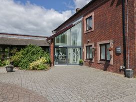 An outdoor view of Jubilee House with plants and a paved area at Bungalow 19 Eamont Park in Penrith