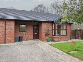 An entrance to a bungalow with a pathway and garden at Bungalow 15 Eamont Park in Penrith