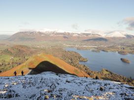 A view of hikers on a mountain trail with a lake in the background at Jubilee Bungalow Pet Friendly Sleeps 4 in Penrith