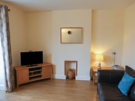 A living room with a television and a lamp at Bungalow 14 Eamont Park in Penrith
