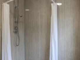 A shower with a shower head and curtain at Bungalow 14 Eamont Park Penrith