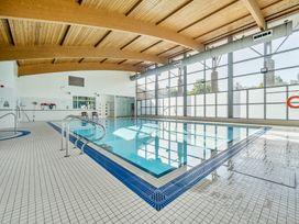 An indoor pool area with tiles and wooden ceiling at Jubilee Ground-floor Double Bedroom in Penrith