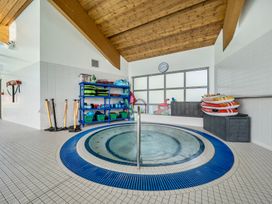 An indoor pool room with a hot tub and shelves of swimming equipment at Jubilee Ground-floor Double Bedroom Penrith