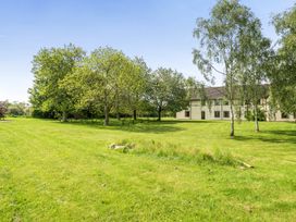 An outdoor view of a grassy area with trees and a building at Jubilee Ground-floor Double Bedroom Penrith