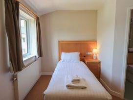 A bedroom with a single bed and bedside table at Eamont Park Ground-floor Single Bedroom Penrith