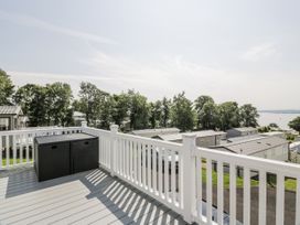 A deck with an outdoor storage container and a view of mobile homes at Number 42 in Wemyss Bay