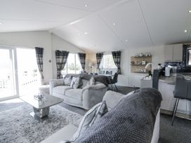 A living room with a sofa and dining area at Number 42 in Wemyss Bay