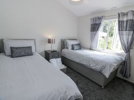 A bedroom with two beds and a lamp at Number 42 in Wemyss Bay