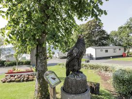 A garden with an eagle sculpture and residential units at Number 42 Wemyss Bay