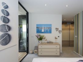 A bedroom with dresser with decorative items and sailboat painting at Two Bare Feet in Rose near Perranporth