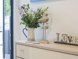 A dresser with a vase of flowers wooden bird figurines and decorative letters spelling love at Two Bare Feet Rose near Perranporth