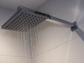 A square overhead shower head with water flowing at Two Bare Feet Rose near Perranporth
