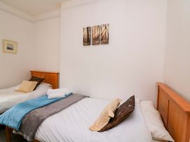 A bedroom with two beds and wall art at Castleview Apartment, 21 South Embankment Dartmouth