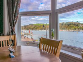 A dining room with a view of boats in the marina at Castleview Apartment, 21 South Embankment Dartmouth