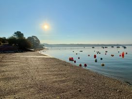 A beach with water and buoys in the bay at The Studio in Feock near Truro
