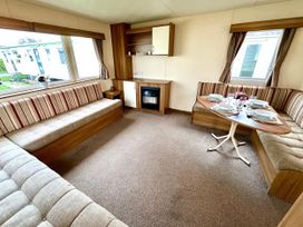 A living room with a dining table and sofa at Chamki Lodge in Whitley Bay