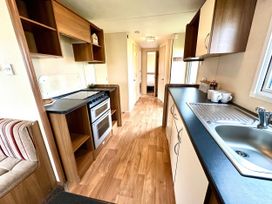 A kitchen with cabinets and a stove at Chamki Lodge in Whitley Bay