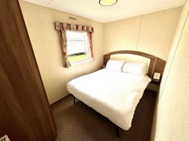 A bedroom with a bed and window at Chamki Lodge in Whitley Bay