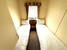 A bedroom with two single beds and a window at Chamki Lodge Whitley Bay