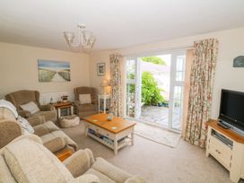A living room with a sofa and a television at The Cottage On The Green in Porthmadog