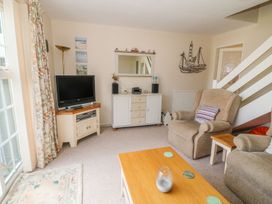 A living room with a television and sofa at The Cottage On The Green in Porthmadog