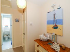 A hallway with painting and table at The Cottage On The Green in Porthmadog