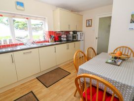 A kitchen with a table and chairs at The Cottage On The Green in Porthmadog