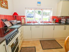 A kitchen with a stove and sink at The Cottage On The Green Porthmadog