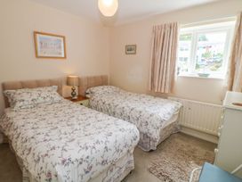 A bedroom with two beds and a window at The Cottage On The Green in Porthmadog
