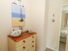 A bedroom with a dresser and painting at The Cottage On The Green Porthmadog