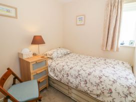 A bedroom with a single bed and bedside table at The Cottage On The Green in Porthmadog