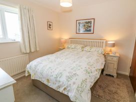 A bedroom with a bed and bedside tables at The Cottage On The Green in Porthmadog