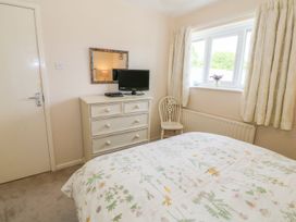 A bedroom with a bed and a television at The Cottage On The Green in Porthmadog
