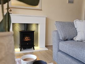 A living room with a fireplace and sofa at The Cottage On The Green in Borth-Y-Gest