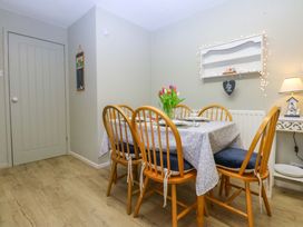 A dining room with a table and chairs at The Cottage On The Green Borth-Y-Gest
