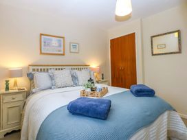 A bedroom with a bed and bedside table at The Cottage On The Green Borth-Y-Gest