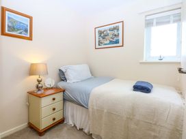 A bedroom with a single bed and bedside table at The Cottage On The Green in Borth-Y-Gest