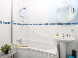 A bathroom with a bathtub and washbasin at The Cottage On The Green Borth-Y-Gest