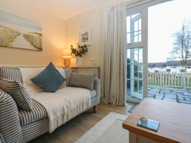 A living room with a sofa and a door to outside at The Cottage On The Green Borth-Y-Gest