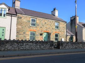 A stone house with windows and a door at Rhows in Niwbwrch (newborough)
