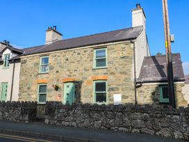 A stone house with windows and a door at Rhows Niwbwrch (newborough)