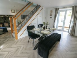 A dining room with a table and chairs at Rhows in Niwbwrch (Newborough)