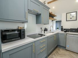 A kitchen with appliances on the counter at Rhows Niwbwrch (Newborough)